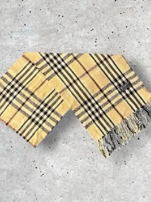 Burberry halsduk - Säljer en snygg Burberry halsduk i den klassiska beige färgen med det välkända rutmönstret. Tillverkad i 100% mjuk och värmande ull. 📏 Mått: Längd-140cm, Bredd-29cm  Pris kan diskuteras!