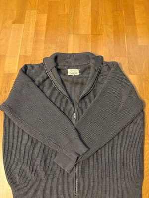 Masion Margiela - Säljer nu denna mörkgråa stickade Masion Margiela Zippen då den är för stor för mig, Den är i helt nytt skick. Pris kan diskuteras vid snabb affär!