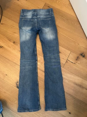 Blå bootcut jeans med slitningar från bershka - Dessa jeans är supersnygga men får inte på mig dom längre. Vanliga bootcut jeans från bershka i storlek 36. Vanliga i längden. Inga skavanker