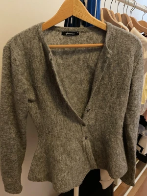 Grå kofta från Gina Tricot - Mysig grå kofta från Gina Tricot med v-ringning och knäppning framtill. Tillverkad i mjukt stickat material och har långa ärmar. Perfekt för lager på lager och enkel att matcha med olika outfits. Hyfsat ny därav priset, bara fråga om fler bilder!💓