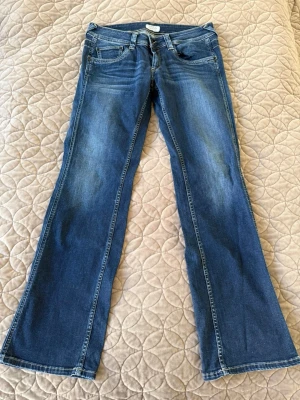 Blå straight leg jeans comfort fit - Snygga blå jeans med straight leg och regular waist. Comfort fit för extra bekvämlighet och klassisk femficksdesign. Jeansen har diskreta slitningar och är perfekta för en avslappnad stil. Materialet är klassisk denim i bomull.