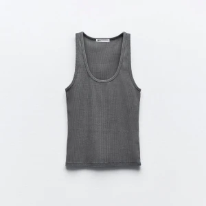 Grå ribbad linnetopp från Zara - Snygg grå ribbad linnetopp från Zara med rund halsringning. Perfekt för lager-på-lager eller att bära som den är. Enkel och stilren design som passar till många olika outfits.