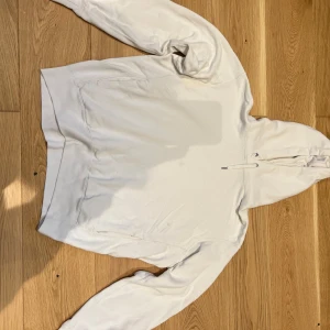 Vit hoodie  - Säljer en stilren vit hoodie. Perfekt för en avslappnad look. Den har långa ärmar och en klassisk passform. Hör av dig vid intresse!