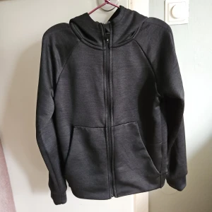 Svart huvtröja med dragkedja - Säljer en svart huvtröja från SDC i storlek 122-128. Tröjan har en dragkedja framtill och en bekväm huva. Perfekt för en avslappnad stil. 🖤