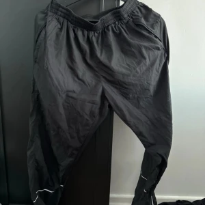 Svarta träningsbyxor från North Bend - Säljer ett par svarta träningsbyxor från North Bend. Byxorna har en elastisk midja och reflekterande detaljer vid bensluten. Perfekta för löpning eller gymmet.