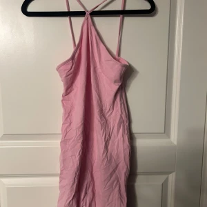 Rosa klänning - Säljer en söt rosa klänning med smala axelband och en enkel design. Perfekt för varma sommardagar eller en avslappnad dag på stan. Klänningen har en lätt och luftig känsla.