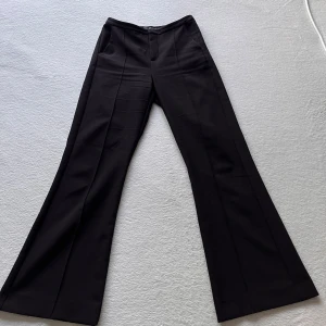 Svarta kostymbyxor från Gina Tricot - Snygga svarta kostymbyxor från Gina Tricot i modellen ”petite bootcut trousers”. Har en medelhög midja och sömmar längs benen 💕