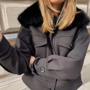 Meotine kappa - Snygg svart jacka med en lyxig pälskrage och knappar framtill. Jackan har en croppad passform och långa ärmar. Perfekt för att hålla stilen i kyligare väder. Storlek Xs/S. En knapp har trillat av men har att på en annan nästan helt identisk. jackan är bra skick men ser inte ut som en ny när man kollar nära 