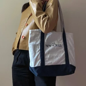 Vintage New Yorker Canvas Tote Bag - Made of a durable canvas cotton, ensuring longevity for carrying essentials. Some navy color fading, and natural wear of logo. Printed The New Yorker Logo. Attached Cotton Keychain Strap to easily spot your keys.  Unlined. Small imperfections are not attributed to a design flaw but to the uniqueness and quality of the product, please appreciate them for their character. Overall Good Condition.  32 CM/ 12.6 IN Length 40 CM/ 15.7 IN Width 29 CM/ 11.4 IN Drop   100% Cotton 