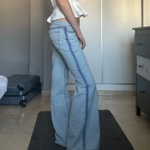 TVÅFÄRGADE bootcut jeans - Såå snygga tvåfärgade bootcut jeans med låg midja! Skitcoola detaljer på sidorna och fickorna där fram o bak, lite tie dye liknande! Storlek M men passar nog även lite större och mindre storlekar. 