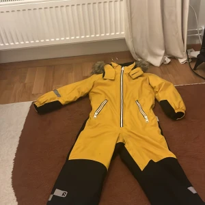 Gul Reima overåll - Gul reima overåll till vintern. (Det står namn på.)