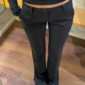 Svarta kostymbyxor - Snygga svarta kostymbyxor med en klassisk bootcut-stil. Dem är låg/mid waisted och knappt använda så dem är nästan i nytt skick.  Nypris 500kr. Pris kan diskuteras.