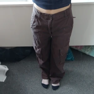 Bruna cargobyxor från Monki - Säljer ett par bruna cargobyxor från Monki. Byxorna har flera praktiska fickor och en loose passform. Perfekta för en avslappnad stil. Tillverkade i ett slitstarkt material.