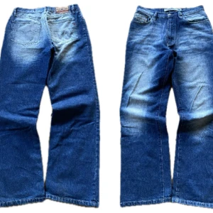 Blå jeans med vida ben - Snygga blå jeans med en cool tvätt och flared/baggy passform. Storlek W32 L32  och De har en klassisk femficksdesign och en bekväm passform. Perfekta för en avslappnad stil.