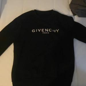 Svart tröja från Givenchy - Snygg svart tröja från Givenchy med deras ikoniska logga tryckt på framsidan. Perfekt för en stilren look. Tröjan har långa ärmar och en klassisk passform.