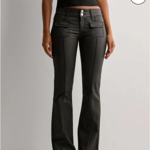 Svarta bootcut byxor med fickdetaljer - Snygga svarta bootcut byxor med hög midja och två knappar framtill. Byxorna har stiliga fickdetaljer och en smickrande passform. Perfekta för en trendig look. Nästan aldrig använda 