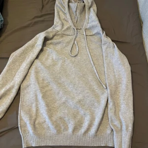 Grå merinoull hoodie - Säljer en stilren grå merinoull hoodie med dragsko i huvan. Tröjan har långa ärmar och ribbade muddar vid ärmslut och nederkant. Perfekt för en avslappnad look. Hör av dig vid minsta fundering! Pris ej hugget i sten, väljer du att köpa fler artiklar från min sida kan jag ge ett ett billiga pris👍 finns även på Vinted!. Fraktar inom 48 h. 