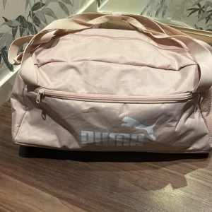 Puma väska  - Säljer en rosa Puma väska. den är använd ganska mycket men är i bra skick dock har den lite slitage men inget stort. minns tyvärr inte vart jag köpte den då det var några år sedan men tror det var stadium. 💕 