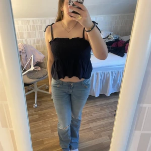 Marinblå croppad linnetopp - Säljer en söt marinblå croppad linnetopp med smockdetaljer och knytbara axelband. Det finns ingen lapp med jag tror att den är i storlek S då den sitter som en. Perfekt för varma dagar och kan enkelt matchas med jeans eller kjol.