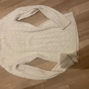 Vit stickad tröja från Ralph Lauren - Säljer en vit stickad tröja från Ralph Lauren med kabelstickat mönster. Amp guldiga knappar vid axeln😍