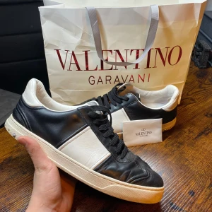 Valentino Flycrew - Exklusiva Valentino Flycrew-sneakers i helsvart! En lyxig och stilren modell som passar perfekt både till vardags och mer dressade outfits. Notera att 6 nitar saknas, men skorna behåller ändå sin unika design och premiumkänsla.  | Färg: Svart ⚫✨ | Skick: Bra skick, men 6 nitar saknas  och en liten spricka vid sulan⚠️ | Modell: Flycrew 🏆 | Storlek: 44 👌 | Box: Originalbox medföljer 📦 | Tillbehör: Extra skosnören och dustbag ingår 👟🎒  |🚚 Leverans: Skickas snabbt via PostNord eller instabox | 