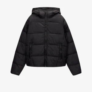 Svart pufferjacka från Pull&Bear - Säljer en svart pufferjacka från Pull&Bear. Jackan har en dragkedja framtill och två sidofickor med dragkedjor. Den är designad med en huva för extra värme och komfort. Perfekt för kyligare dagar.