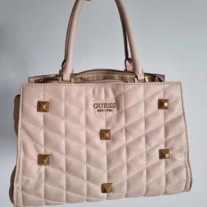 Ljusrosa handväska från Guess - Säljer en superfin ljusrosa handväska från Guess i mycket bra skick. Den har många rymliga fack! Buda gärna💗💗💗
