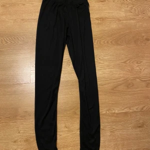 Svarta byxor från Newbody - Säljer ett par svarta byxor från Newbody i storlek XS. De är gjorda av 100% polyester och har en elastisk midja för extra komfort. Perfekta för en avslappnad dag hemma eller lätt träning. Byxorna är i nyskick och superbekväma!