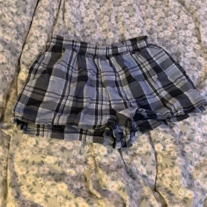 Rutiga  pyjamasshorts från H&M - Säljer ett par superbekväma och stiliga rutiga shorts från H&M. De är i en snygg kombination av blå, svart och vit. Perfekta för en avslappnad dag eller som pyjamas. Passar perfekt för varma nätter.