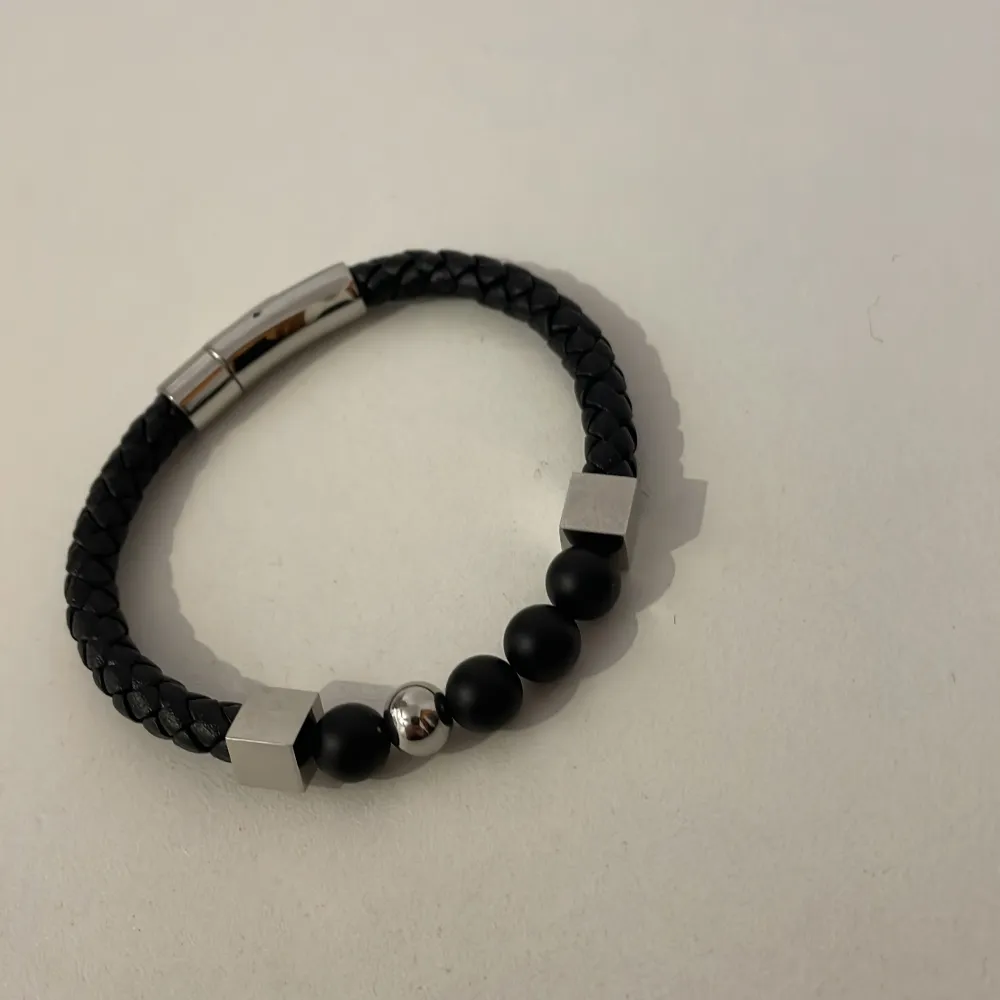 Säljer ett läderarmband med stilrena detaljer! Armbandet passar till många kläder, färger och tillställningar. Det har en bra läsfunktion för lätt påtagning, pärlor och kuber som detaljer. Condition: 9/10. Tveka inte att höra av dig vid frågor!🤝😁💯. Accessoarer.