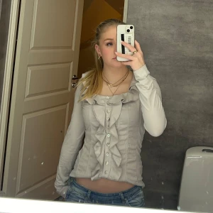 Topp med volanger  - Jättefin beige/ grå topp med volanger i storlek s 