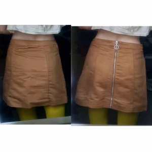 Imitationsmocka a-linje kjol blixtlås 36 - Fint skick. 100% polyester. Sitter lägre på mig än jag önskat, så anser den för stor. Men smaksak hur man vill att den sitter. Midjevidd: 36, stussvidd: 53, längd: 38,5.