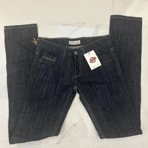 Mörkblå jeans  - Snygga mörkblå jeans i klassisk femficksmodell. De har en straight passform och är dekorerade med kontrastsömmar. Perfekta för både vardag och fest! 