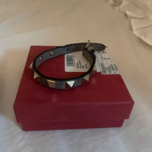 VALENTINO ARMBAND - Säljer detta valentino armbandet till billigt pris. Använt men har mycket att ge nästa peroson, säljs billigt då det är litet sliter vi spänner som ni kan se på bilden🤗🤗💕har tyvärr ej kvar kvittot men har orginalbox, extra nitar samt äkthetsbevisen.