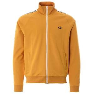 Säljer en snygg gul track jacket från Fred Perry. Den har en vit dragkedja och de klassiska Fred Perry-loggorna längs ärmarna. Perfekt för en sportig och stilren look! 🧡 Nyskick. frakt tillkommer. Tar ej returer