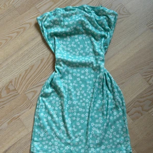Blommig Sommarklänning/miniklänning - Jättesöt blommig sommarklänning/miniklänning i ljusgrön. Köpt för länge sedan men i bra skick fortf. 