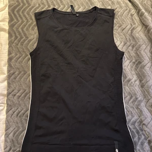 Svart och vitt tränings linne - Säljer ett svart mer tränings linne med vit kant på båda sidorna, väldigt stretchigt så extremt bekvämt att ha på sig! Från Åhléns i storlek M men passar även som S🙌🏼 skriv vid frågor!
