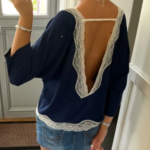 Mörkblå spetsblus med öppenrygg - Blå trekvartsärmad blus/topp med spets och öppen rygg från Molly Bracken. Storlek M. Fint skick. Använd gärna köp nu!