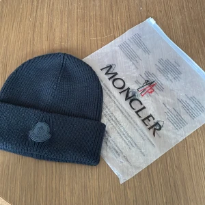 Moncler mössa  - Svart moncler mössa. 10/10 skick, aldrig använd. Perfekt nu till hösten/vintern. Pris kan diskuteras. Skriv vid funderingar!