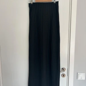 Lågmidjade långkjol - Lågmidjad långkok från Gina som är lite glittrig. Jag är 173 lång och den går ända ner till fötterna! 