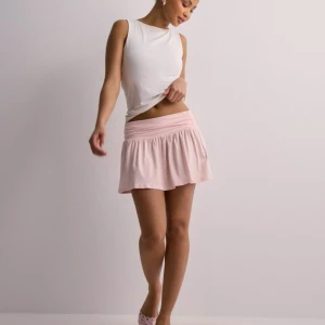 Söt rosa kortkjol - Säljer en superfin rosa kortkjol. Kjolen har en bred resår i midjan som gör den bekväm och lätt att bära. Använd bara en gång och absolut inga tecken på användning 