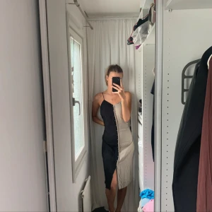 Silkesliknandd klänning två färger med knappar - Härlig klänning med i två färger. Luftig och perfekt för väldigt varma sommardagar! Finns ingen lapp då den är bortklippt men passar de flesta beroende vad för passform man önskar! (För referens har jag s) felfritt skick och oanvänd