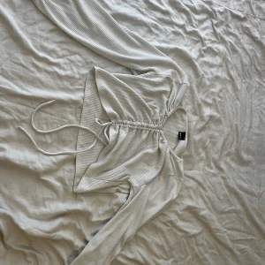 Vit tröja  - En vit långärmad tröja med justerbar längd.