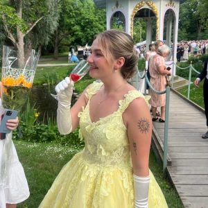 Gul balklänning 💛 - Säljer min fina balklänning som gjorde sig susen under balen i Linköping 2024💛 Kläningen är i fint skick och köptes för 7000kr. Jag är 164 cm lång.  Klänningen består av väldigt ljusgul spets med blommor och fjärilar. Underkjol ingår i priset☺️
