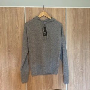 Carmes Kashmir hoodie (aldrig använd) - Säljer en stilren och bekväm grå kashmir hoodie från Carmes. Den är aldrig använd sprillans ny med lapp kvar. Den är perfekt för både vardag och mysiga hemmakvällar. Tröjan har långa ärmar och en klassisk huva. 