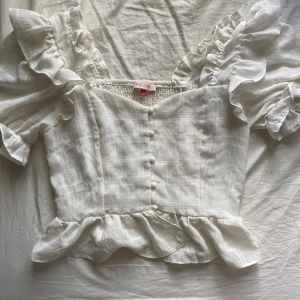 Volang tröja - Vit gullig volang tröja som passar till det mesta. Vet inget om märket men ser ej ut att vara fast fashion! 