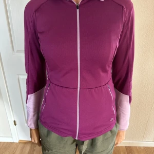 Lila tröja från Galvin Green - Säljer en snygg lila golf tröja från Galvin Green i storlek XS. Den har en dragkedja framtill och är långärmad med en cool design på ryggen i ljusare lila. Tröjan är i bra skick bortsett från armen då det blivit ett litet hål (sista bilden) 