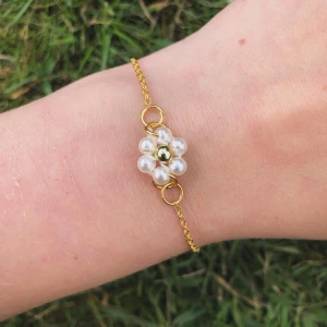 Armband i rostfritt stål med en pärlblomma  - Jätte fint armband i rostfritt stål med en blomma gjort av pärlor i mitten! Armbandet e handgjort av mig 