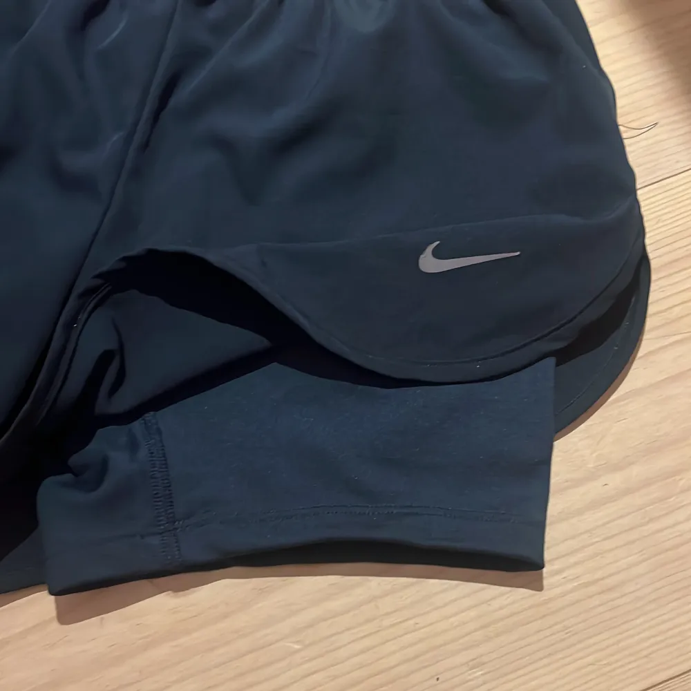 Mörkblå Nike shorts med resprmidja, snören och undershorts. Storlek m men passar s-m cirka. Använda få gånger. Säljer då de är förstora. Skriv för frågor mm. 🥰. Sportswear.