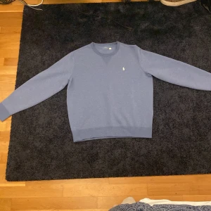 Blå Polo ralph lauren sweatshirt - Säljer en ljusblå Polo Ralph lauren sweatshirt som knappt har använts. Storlek L 180/100A. Sjukt bra skick och tröjan funkar till alla möjliga tillfällen